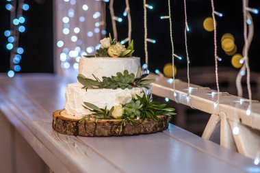 yakın çekim çiçek ve kutlama için yeşil yaprakları ile lezzetli düğün pastası