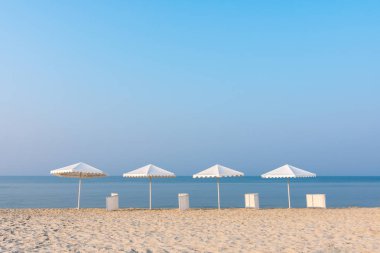 Kumsal beyaz plaj şemsiyeleri ile doğal görünümünü