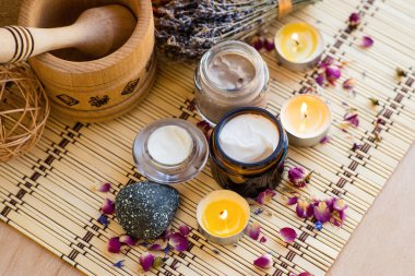 Yanan mumlar ve lavanta buket ile bambu halı üzerinde krem kavanoz 