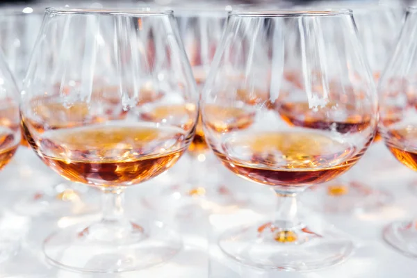 Beyaz masa örtüsü ile tabloda düzine cam aşısı brendi ile Görünümü Kapat 