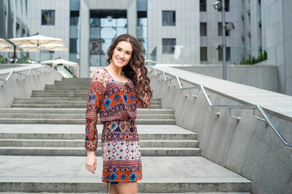 Bina Arka Plan Üzerinde Renkli Elbise Poz Genç Kadın — Stok fotoğraf