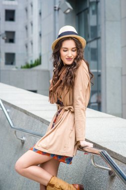 genç kadın palto ve şapka binalar zemin üzerine poz