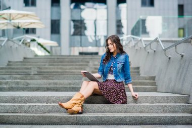 genç kadın merdivenlerde oturan ve tablet PC'yi kullanma  