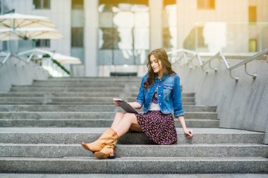 genç kadın merdivenlerde oturan ve tablet PC'yi kullanma  