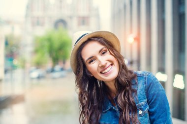 Kot ceket ve şehir yürüyüş sırasında poz şapka genç kadın