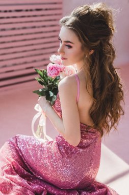 Taze çiçekler ile poz içinde muhteşem bir genç kadın 