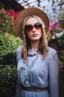 Güzel genç kadın güneş gözlüğü ve mavi elbise poz ile şık şapka 