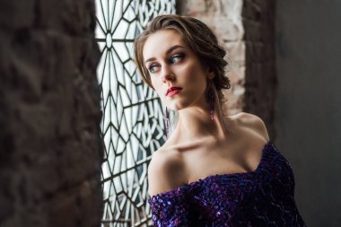 studio penceresinde yakınındaki poz moda mor elbise giyen güzel genç kadın 