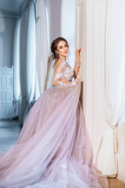 young beautiful bride in gorgeous dress posing indoors 