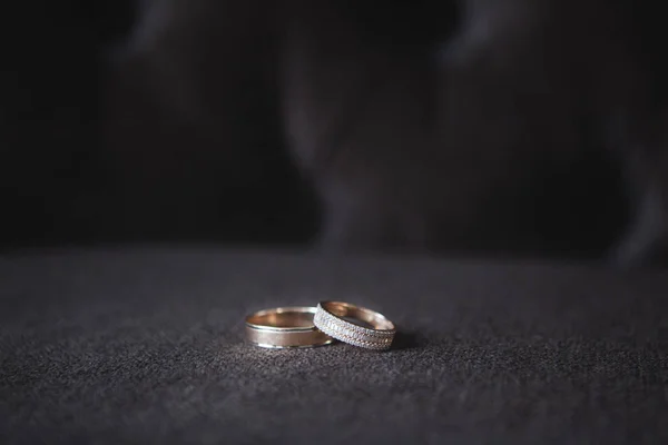 Dua cincin emas pernikahan di latar belakang gelap — Stok Foto