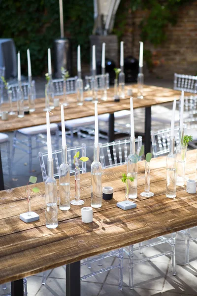 Candele bianche in bottiglie di vino stand su tavolo bianco — Foto Stock