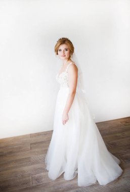 Arka plan beyaz duvardaki giysi güzel bir beyaz düğün güzel gülümseme mutlu gelin. Güzel dantel dekolte