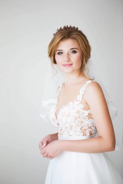 Arka plan beyaz duvardaki giysi güzel bir beyaz düğün güzel gülümseme mutlu gelin. Güzel dantel dekolte