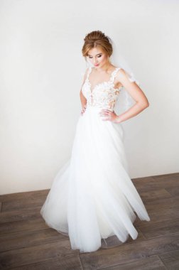 Arka plan beyaz duvardaki giysi güzel bir beyaz düğün güzel gülümseme mutlu gelin. Güzel dantel dekolte