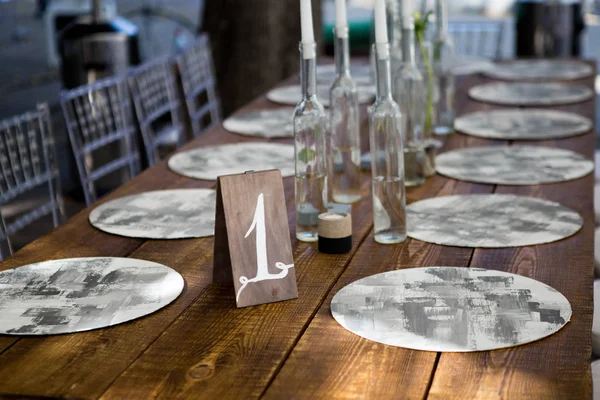 Mesa con comida y flores en la boda. El número 1 escrito en la tarjeta blanca está parado antes del ramo en el centro de la mesa de la cena Imagen De Stock