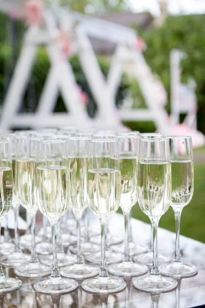 Glazen champagne witte wijn. Glazen van glas met gekleurde dranken op tafel — Stockfoto