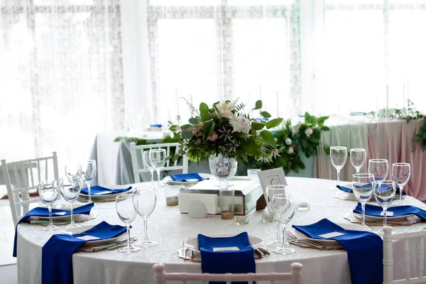 Bella tavola apparecchiata con tovaglia bianca e tovaglioli blu — Foto Stock