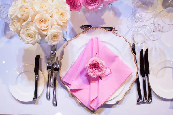 Красива обстановка столу з білою скатертиною і рожевими серветками. Червоні столові прибори, красиве обіднє начиння. Весільний Декор Текстиль — стокове фото
