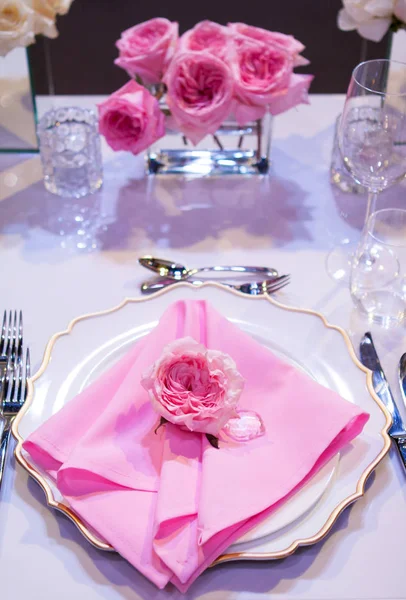 Hermosa mesa con un mantel blanco y servilletas rosas. Cubertería roja, hermosos utensilios de comedor. Decoración de la boda Textiles — Foto de Stock