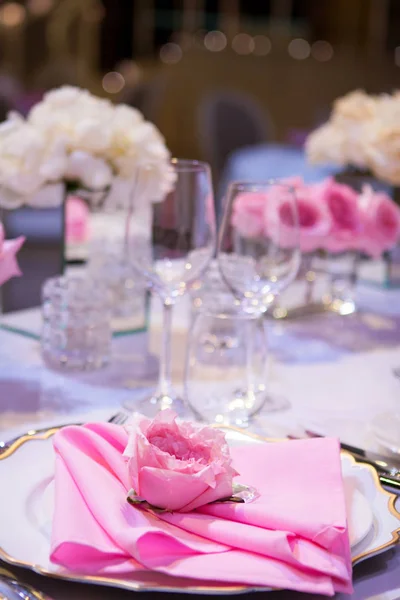 Όμορφο πίνακα ρύθμιση με ένα λευκό τραπεζομάντιλο και χαρτοπετσέτες ροζ. Κόκκινο μαχαιροπήρουνα, όμορφα σκεύη φαγητού. Υφάσματα διακόσμηση γάμου — Φωτογραφία Αρχείου