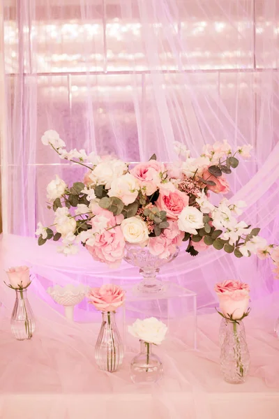Bellissimo arredamento con tessuto e fiori. Un grande vaso con fiori bianchi e rosa. Piccoli vasi con rose — Foto Stock