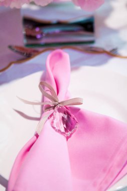 Beyaz masa örtüsü ve pembe peçete ile güzel sofra. Kırmızı çatal bıçak takımı, güzel yemek mutfak eşyaları. Düğün dekor Tekstil