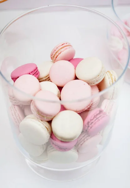 Macarrones carmesí blanco rosado se encuentran en un jarrón transparente —  Fotos de Stock