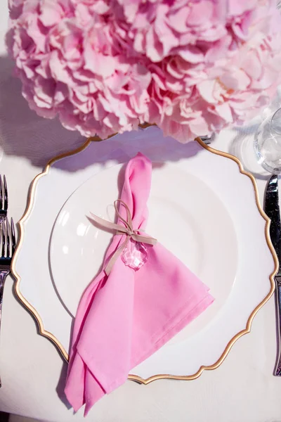 Bella tavola apparecchiata con tovaglia bianca e tovaglioli rosa. Posate rosse, bellissimi utensili da pranzo. Decorazione di nozze Tessile — Foto Stock