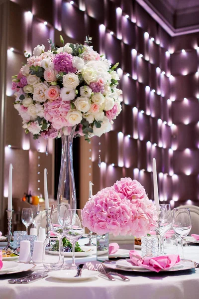 Mooie tafel setting met een wit tafellaken en roze servetten. Rood bestek, mooie eetkamer gebruiksvoorwerpen. Bruiloft Decoratie textiel — Stockfoto