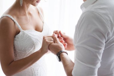 Pencerenin önünde el ele tutuşarak damat ile gelin