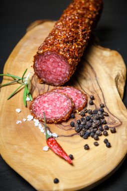 koyu arka plan üzerinde kırmızı toz biber kurutulmuş salam kabuklu