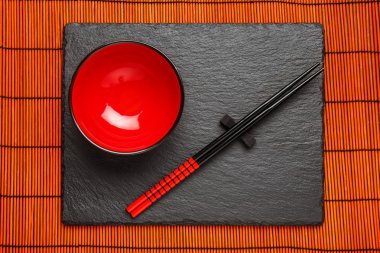 İki çubuk ve boşaltmak siyah taş zemin üzerine kırmızı plaka