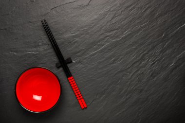İki çubuk ve boşaltmak, üstten görünüm siyah taş zemin üzerine kırmızı plaka