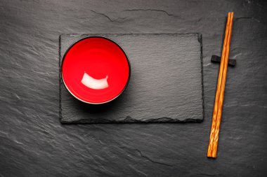İki çubuk ve boşaltmak, üstten görünüm siyah taş zemin üzerine kırmızı plaka
