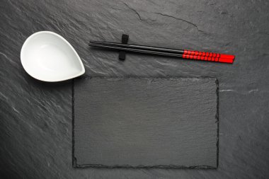 İki çubuk ve boşaltmak, üstten görünüm siyah taş zemin üzerine beyaz kase