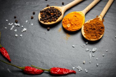 baharat siyah taş zemin üzerine tahta kaşıklar, kopya alanı ile üst görünüm