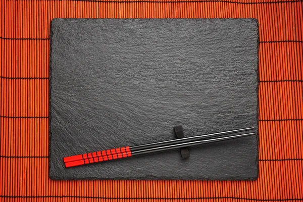 Two chopsticks  on black stone background with copyspace — Stock Photo, Image