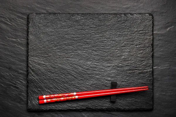 Two chopsticks on black stone background with copyspace, top view — Stock Photo, Image