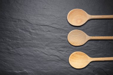 Kara barut tahta sunumu ile üç tahta kaşıklar, üstten görünüm