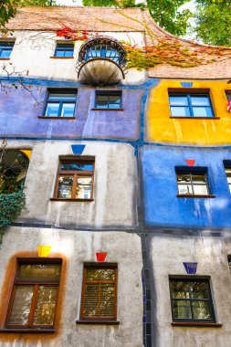 VIENNA, AUSTRIA - October 14, 2016: Facade of Huntdertwarsser house in Vienna. The Hundertwasser House is one of Vienna's most visited buildings and has become part of Austria's cultural heritage clipart
