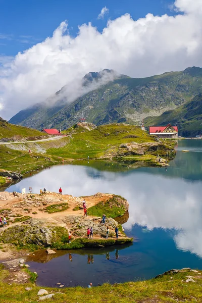 LAGO DE BALEA, RUMANIA - 21 DE JULIO DE 2014: Los turistas no identificados disfrutan de las vistas del lago Balea a 2.034 m de altitud en las montañas de Fagaras, Rumania . — Foto de Stock