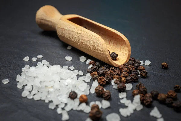 Черный перец и соль на деревенском каменном фоне. Фотография продуктов питания — стоковое фото