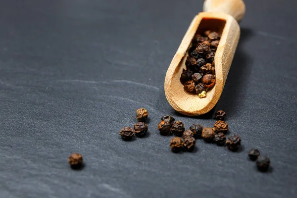 Black pepper and salt on rustic stone background. Overhead view food photography — Stock Photo, Image