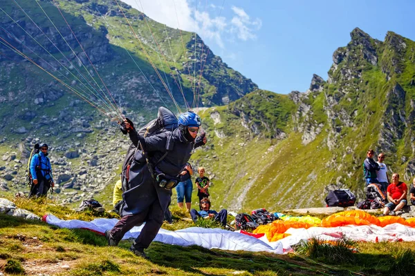 Lago Balea, Rumania - 21 de julio de 2014: Parapente no identificado en el Lago Balea, Montaña Fagaras, Rumania. El parapente es uno de los deportes de aventura más populares del mundo —  Fotos de Stock