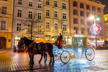 Krakow, Polonya - 22 Ocak 2017: Atlı arabası Main Market Square Krakow, gece görüş, Polonya tarihinde Sukiennice önce