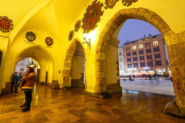 KRAKOW, POLÓNIA - 02 de janeiro de 2017: Sukiennice e Igreja de Santa Maria à noite em Cracóvia, Polônia — Fotografia de Stock