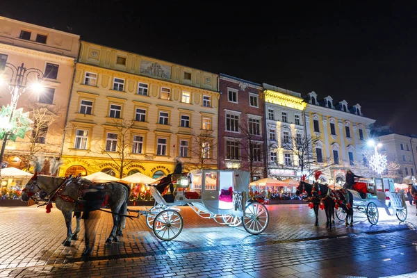 Krakow, Polonya - 22 Ocak 2017: Atlı arabası Main Market Square Krakow, gece görüş, Polonya tarihinde Sukiennice önce — Stok fotoğraf