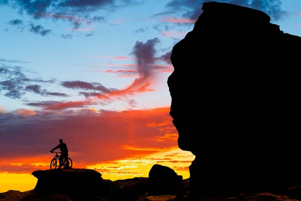 Mountain bicycle rider on the hill with sunset background — Stock Photo, Image