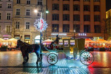 Krakow, Polonya - 22 Ocak 2017: Atlı arabası Main Market Square Krakow, gece görüş, Polonya tarihinde Sukiennice önce