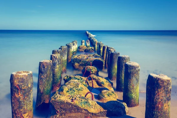 Antiguo rompeolas en el mar Báltico al atardecer, larga exposición — Foto de Stock